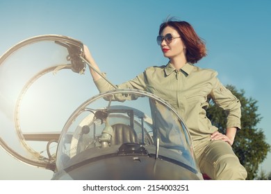 Commercial And Military Aviation. Beautiful Happy Woman Pilot Dressed In Uniform And Sunglasses Poses In Her Aircraft Cockpit Ready For Take Off. 