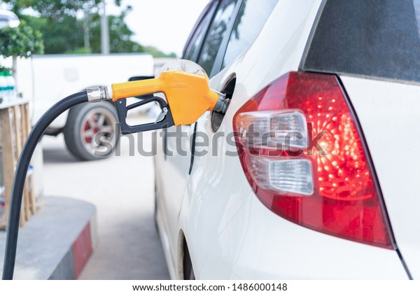 Commercial petroleum filling;woman\
service transfer gas from gas station to the white car\
.