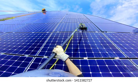 Commercial Solar Panel Washed By Blue Collar Worker
