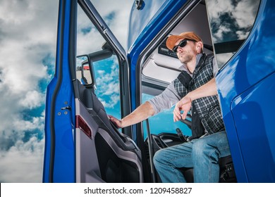 Commercial Truck Driver On Duty. Caucasian Semi Truck Driver Awaiting New Cargo In The Parking Area.