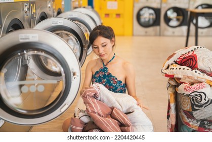 Commercial Washing Machine Business.A Beautiful Woman Uses A Washing Machine At A Store.The Modern Washing Machine Utility Is An Electrical Appliance.Clothing Cleaning Industry