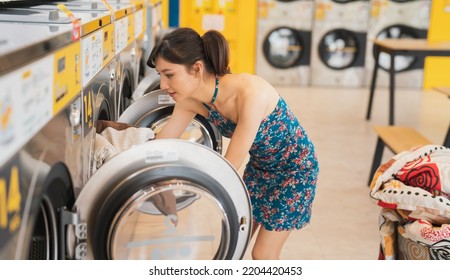 Commercial Washing Machine Business.A Beautiful Woman Uses A Washing Machine At A Store.The Modern Washing Machine Utility Is An Electrical Appliance.Clothing Cleaning Industry