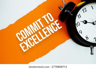 Commit To Excellence with alarm clock on orange background