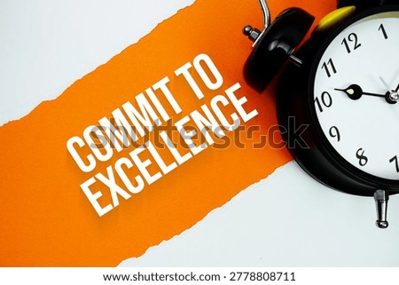 Commit To Excellence with alarm clock on orange background