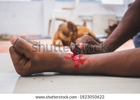 Committed Suicide Concept - man suicide by knife cutting a wrist, Depressed man, Sad love, low self esteem, the knife hand and a lot of blood. to cut my veins on the hand with a kitchen knife.