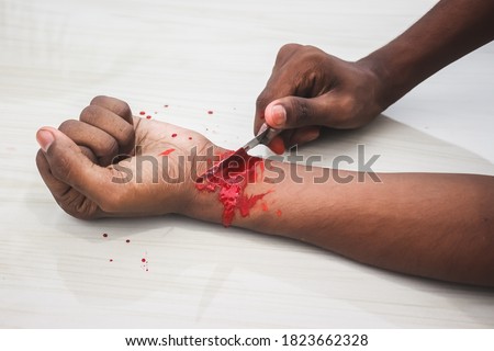 Committed Suicide Concept - man suicide by knife cutting a wrist, Depressed man, Sad love, low self esteem, the knife hand and a lot of blood. to cut my veins on the hand with a kitchen knife.