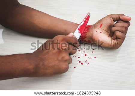 Committed Suicide Concept - man suicide by knife cutting a wrist, Depressed man, Sad love, low self esteem, the knife hand and a lot of blood. to cut my veins on the hand with a kitchen knife.