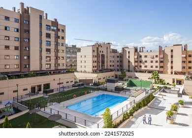 Common areas of an urbanization with swimming pools, benches and flower boxes and a lot of grass and tennis courts - Shutterstock ID 2241572025