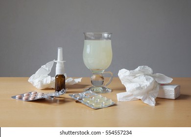 Common Cold Or Flu Remedy. Hot Lemonade, Nasal Spray, Pills, And Tissues