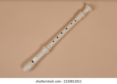 Common fipple flute closeup, beige background. Flute belong to group of woodwind musical instruments. Aerophone or reedless wind instrument that produce sound from flow of air across opening. - Shutterstock ID 2133811811