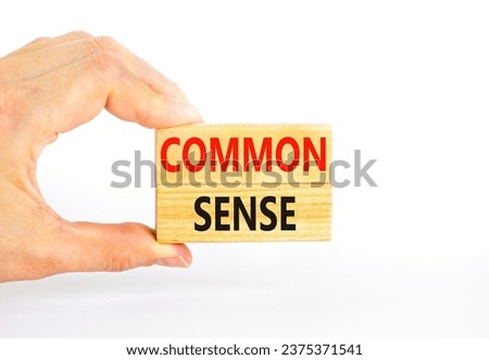 Common sense symbol. Concept words Common sense on beautiful wooden block. Beautiful white table white background. Businessman hand. Business, motivational common sense concept. Copy space.