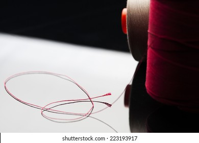 common thread  cotton yarn red leaning white table mirror and black shade  spool red cotton