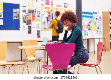 Communal Area Of Busy College Campus With Female Student Working At Table