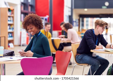 Communal Area Of Busy College Campus With Students Working At Tables