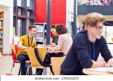 Communal Area Of Busy College Campus With Students Working At Tables