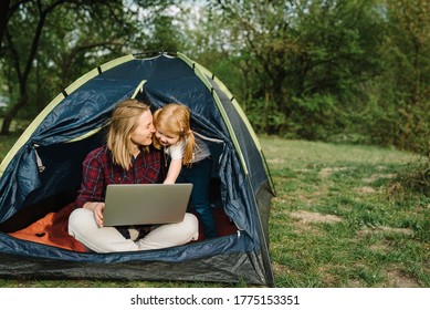 Communicate with relatives, family online on laptop in tent in nature. Woman worker speak talk on video call with colleagues. Mother working with kid. Child make noise and disturb mom. - Powered by Shutterstock