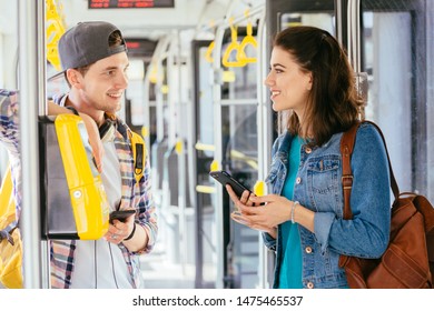 Communication, acquaintance, friendship concept. Young female asking for help handsome male with backpack for paying ticket with smartphone and ticket machine in modern tram during ride. - Shutterstock ID 1475465537