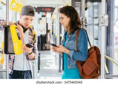 Communication, acquaintance, friendship concept. Young female asking for help handsome male with backpack for paying ticket with smartphone and ticket machine in modern tram during ride. - Shutterstock ID 1475465543