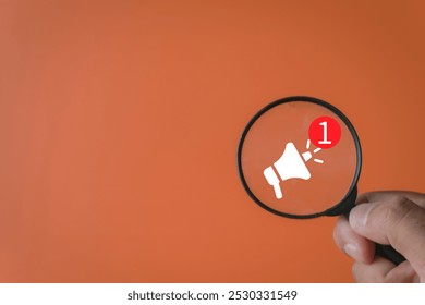 Communication, Announcements, and Social Media Notifications,Digital Communication, Marketing concept.,Hand holding magnifying glass and focus on megaphone with notification alert icon. - Powered by Shutterstock