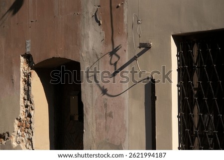 communication cables cast a shadow on the wall of the building in the form of a cartoon face 
