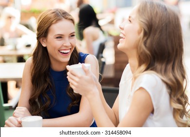 Communication And Friendship Concept - Smiling Young Women With Coffee Cups At Cafe