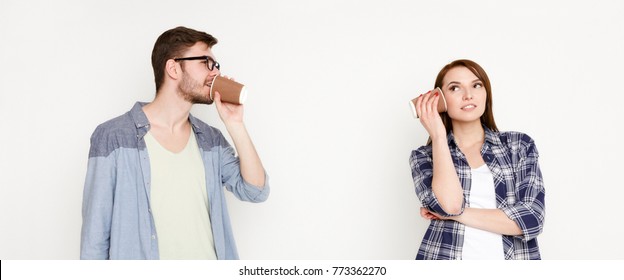 Communication And Fun. Young Casual Couple Talking Through Tin Can Phone, Isolated On White Background