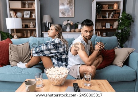 Communication problems, relationship difficulties. Young couple man and woman sitting on sofa at home, not talking after argue and misunderstanding. Two sad people having issue with ego and guilt.