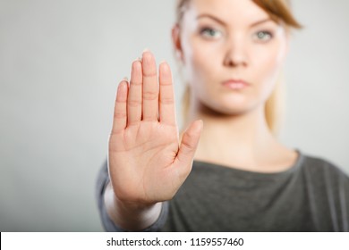 Communication psychology negative defensive concept. Assertive woman making stop gesture. Strong blonde lady showing hold sign.