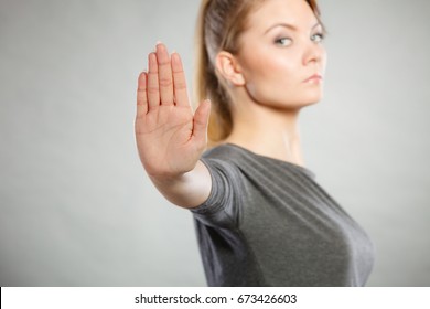 Communication psychology negative defensive concept. Assertive woman making stop gesture. Strong blonde lady showing hold sign.