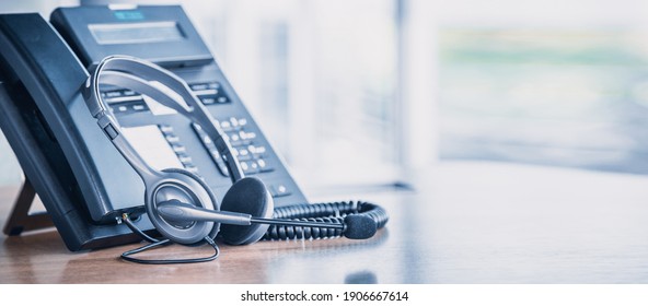 Communication Support, Call Center And Customer Service Help Desk. VOIP Headset On Telephone Keyboard.