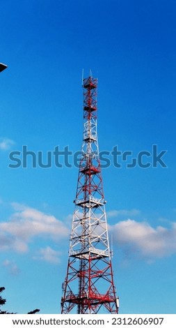 A communication tower set against a backdrop of blue sky with vertical photos