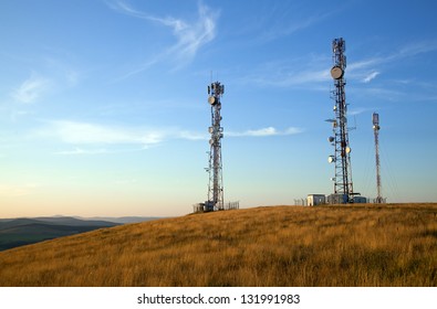 communication towers on top of hill with blue sky background