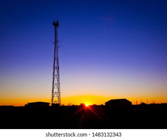 Communications Tower. Cell tower for phone network. Digital communications. Electromagnetic radiation. Silhouette of radio tower on sunset.