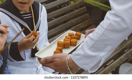 Communion Celebration At Restaurant. Boys Dressed With Traditional Sailor Suit Eating Spanish Starter Called Croquetas.