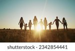 community large family in the park. a large group of people holding hands walking silhouette on lifestyle nature sunset in park. big family kid dream concept. people in the park. large family