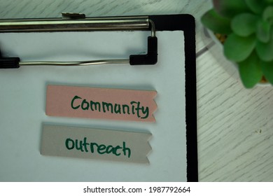 Community Outreach Write On Sticky Notes Isolated On Wooden Table.