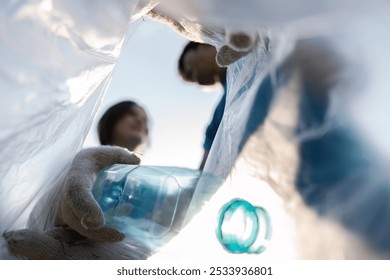 Community Volunteer Collecting Plastic Bottles for Recycling in Environmental Cleanup Effort - Powered by Shutterstock