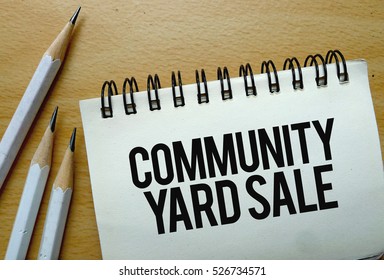 Community Yard Sale Text Written On A Notebook With Pencils