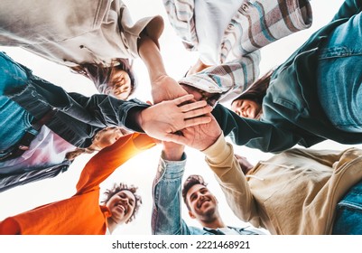 Community of young people stacking hands together - Multiracial college students putting their hands on top of each other - Human relationship, social, community and college concept - Powered by Shutterstock