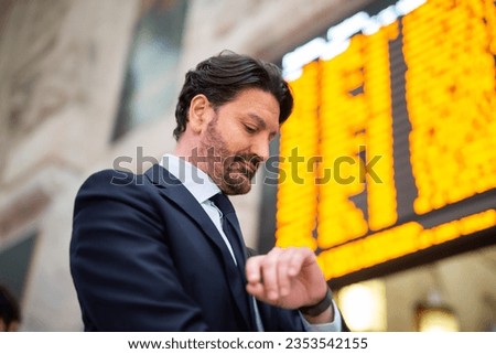 Commuter checking time in front of a timetable