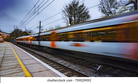 Commuter Train Departing A UK Station And Gathering Speed