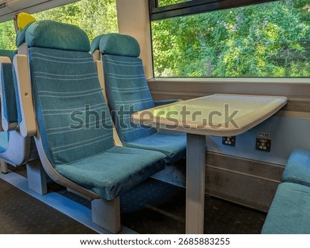 A commuter train interior with table and seating but no people