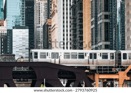 Commuter train passing on elevated railway bridge in downtown Chicago city center. Urban transit, transportation infrastructure, metropolitan commute and public travel concept.