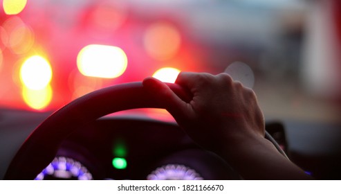 Commuter Waiting In Traffic Jam. Close-up Hand Holding Steering Wheel Stuck In Traffic POV