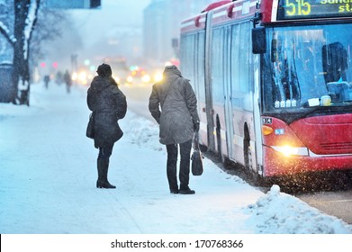Commuters waiting for arriving bus in snowstorm
