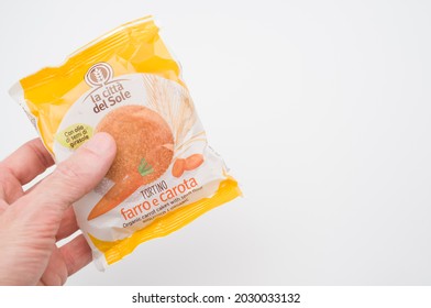 COMO, ITALY - Aug 12, 2021: A Male Hand Holding A Plastic Package Of A Natural Organic Carrot Cake With Spelt Flour, With Free Space For Text