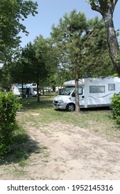 Como Italy. European Coach Built Motor Home Parked In A Camp Site Pitch Surrounded By Luxuriant Trees And Lush Vegetation. No People. 