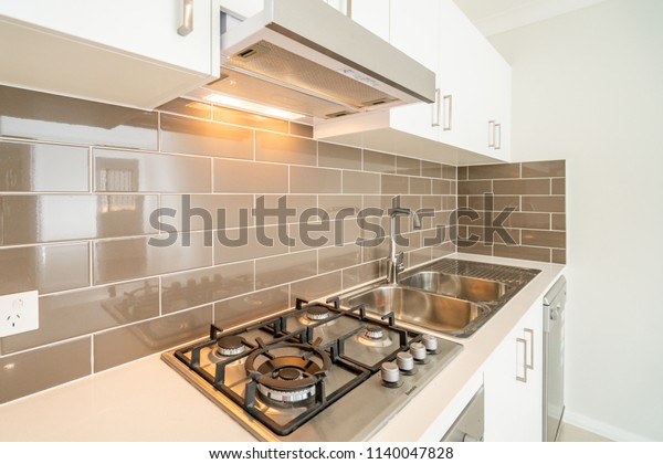 Compact Australian house kitchen with cooktop,\
stove, sink, dish
