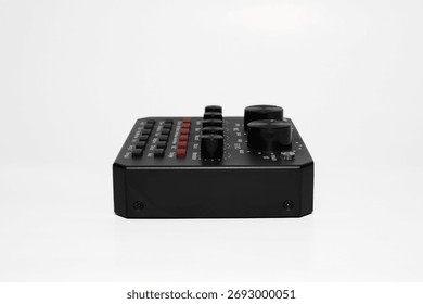 Compact, black audio interface with multiple buttons, knobs, input, and output ports isolated on white background. It's audio sound card for music equipment and recording, easy to use.