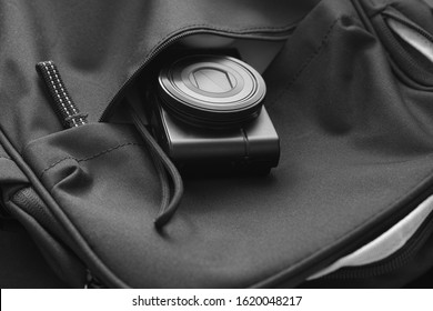 Compact camera inside a backpack. Black and White. Close up.